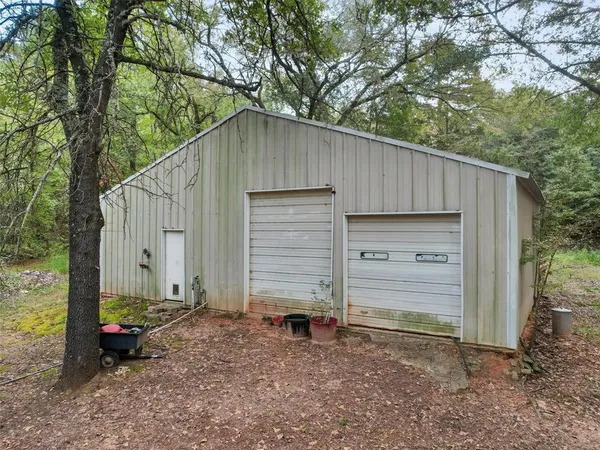 a backyard of a house with a small barn and wooden fence