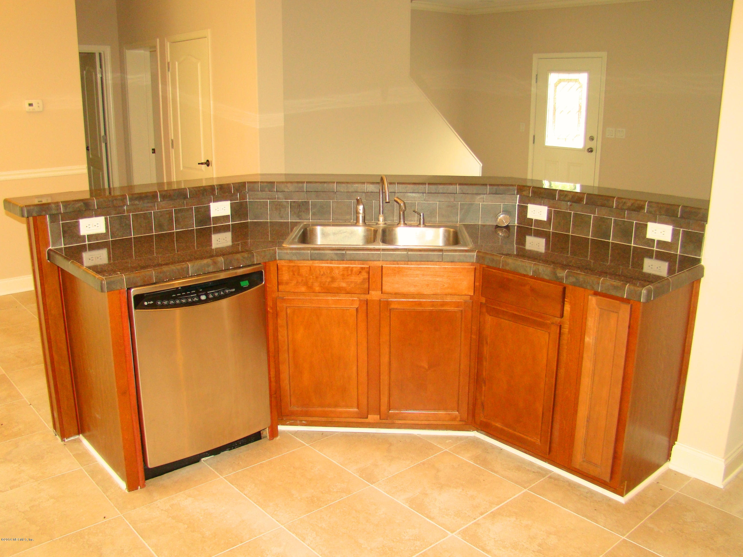 1716 Mccaul Road Jacksonville, FL 32220 - Photo 10 of 25 a view of a kitchen with an empty room and wooden floor