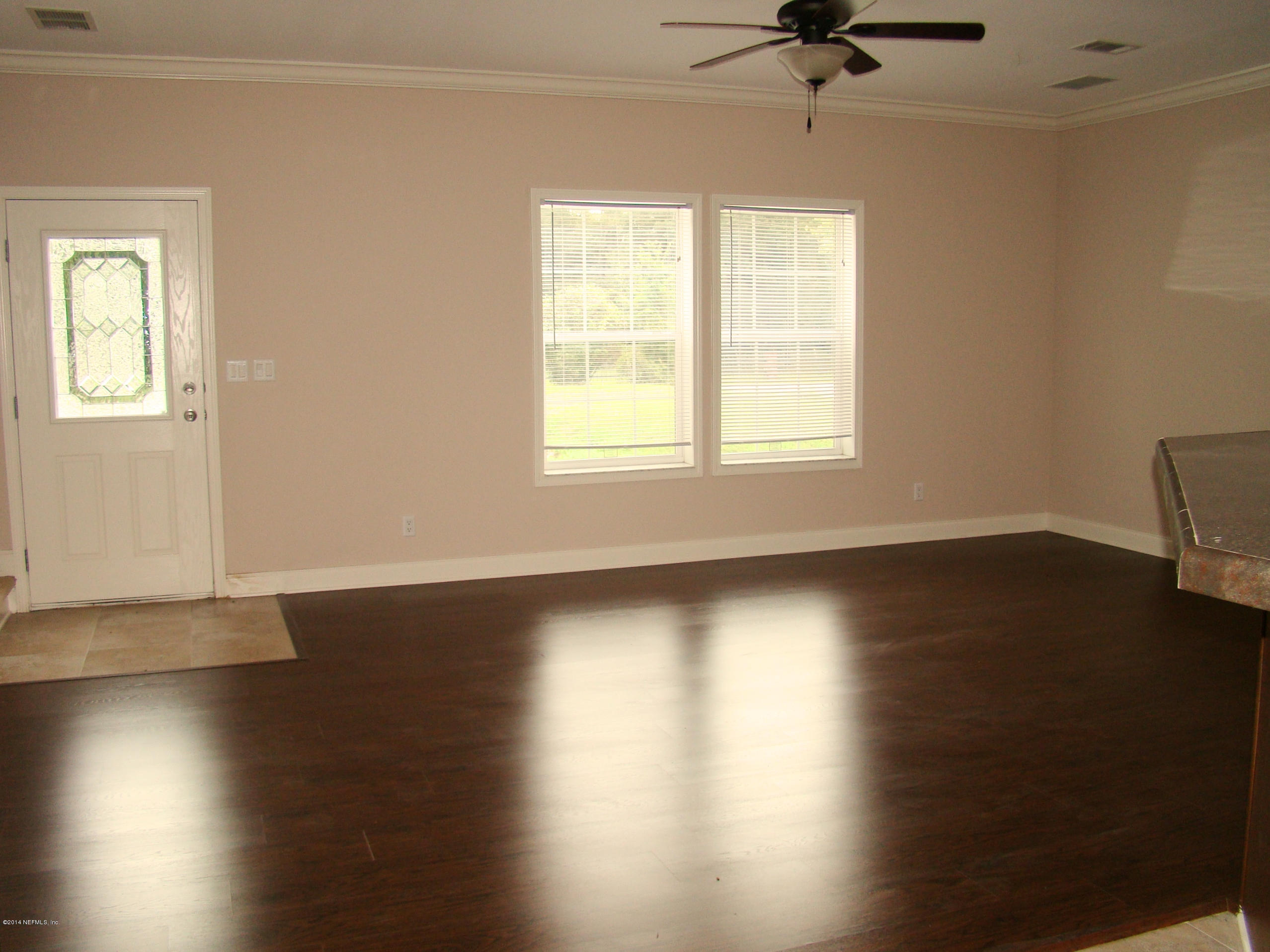 1716 Mccaul Road Jacksonville, FL 32220 - Photo 5 of 25 a view of an empty room with wooden floor and a window