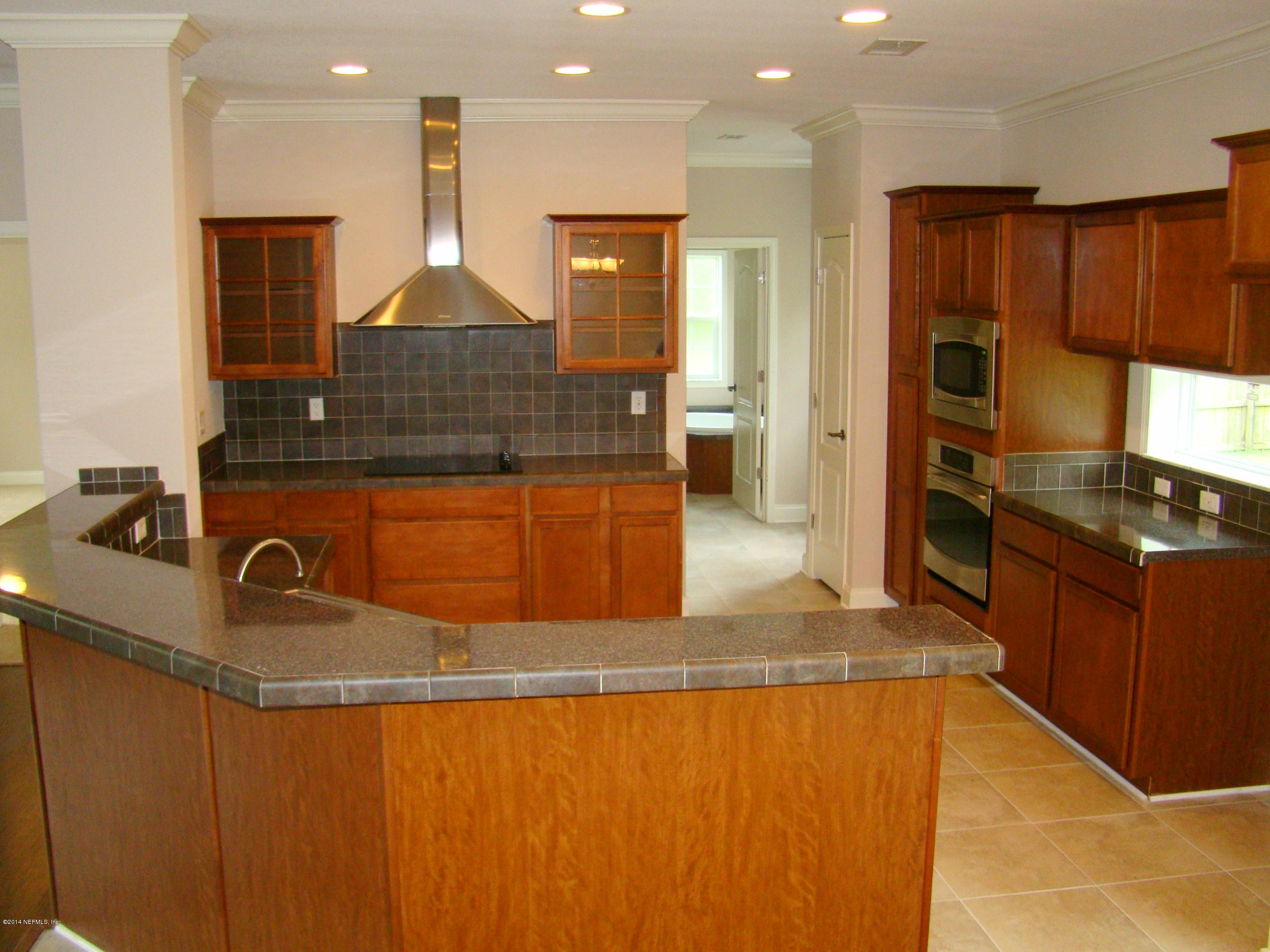 1716 Mccaul Road Jacksonville, FL 32220 - Photo 6 of 25 a kitchen with kitchen island granite countertop a sink a stove and refrigerator