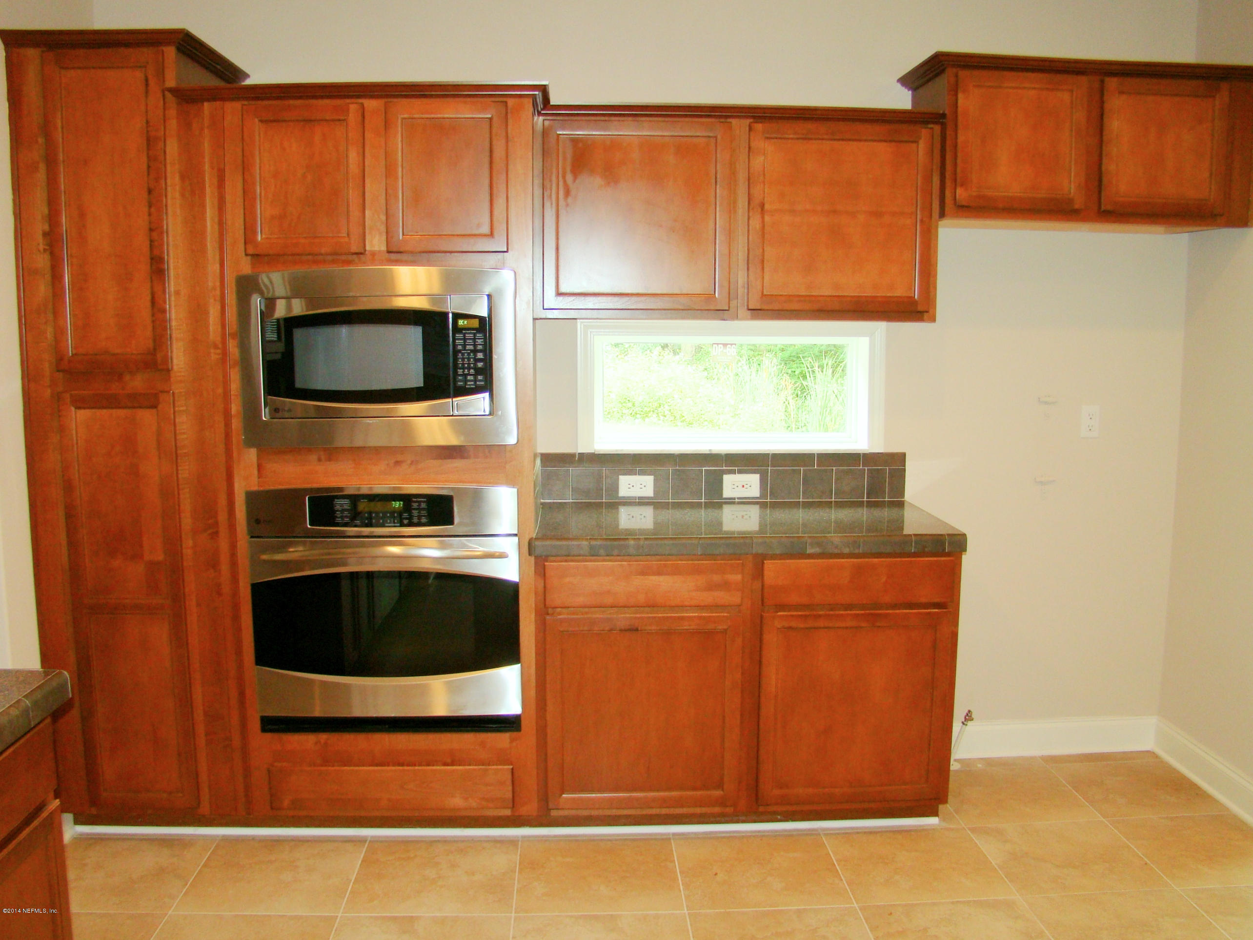 1716 Mccaul Road Jacksonville, FL 32220 - Photo 9 of 25 a kitchen with stainless steel appliances wooden cabinets and a stove top oven