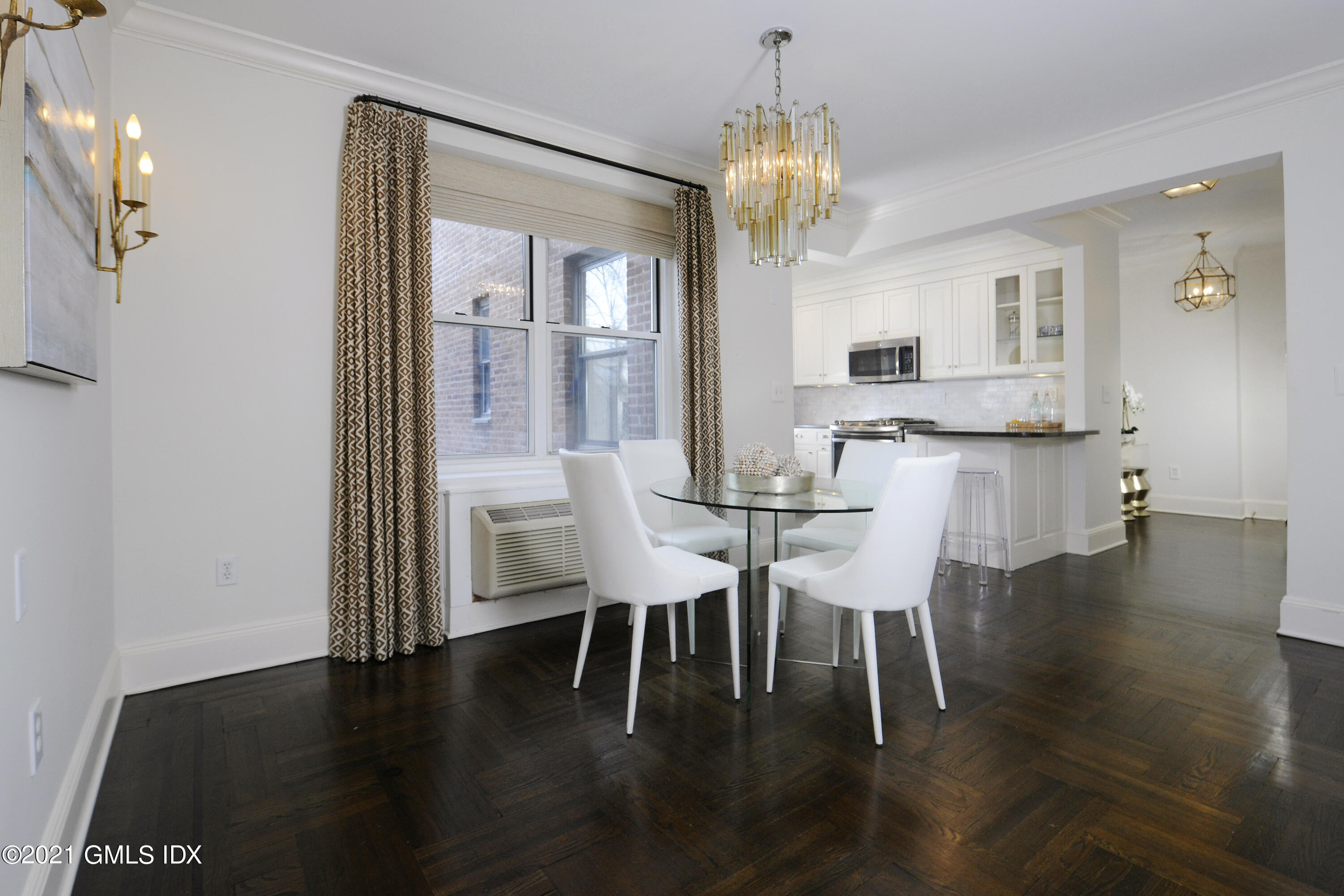 25 West Elm Street, Unit 47 Greenwich, CT 06830 - Photo 6 of 18 a dining room with wooden floor a chandelier a glass table and chairs
