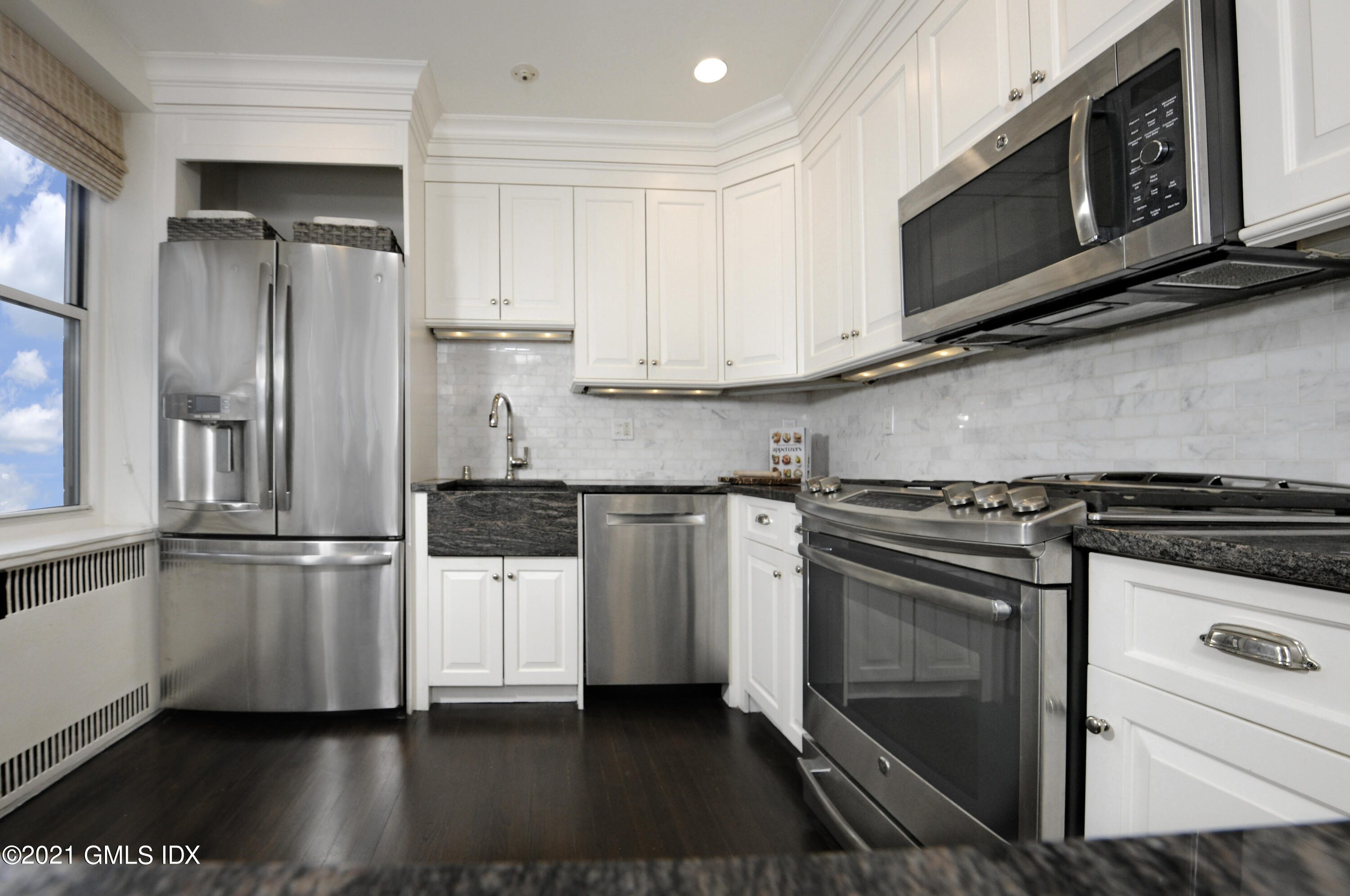 25 West Elm Street, Unit 47 Greenwich, CT 06830 - Photo 10 of 18 a kitchen with stainless steel appliances granite countertop a stove a refrigerator and a microwave