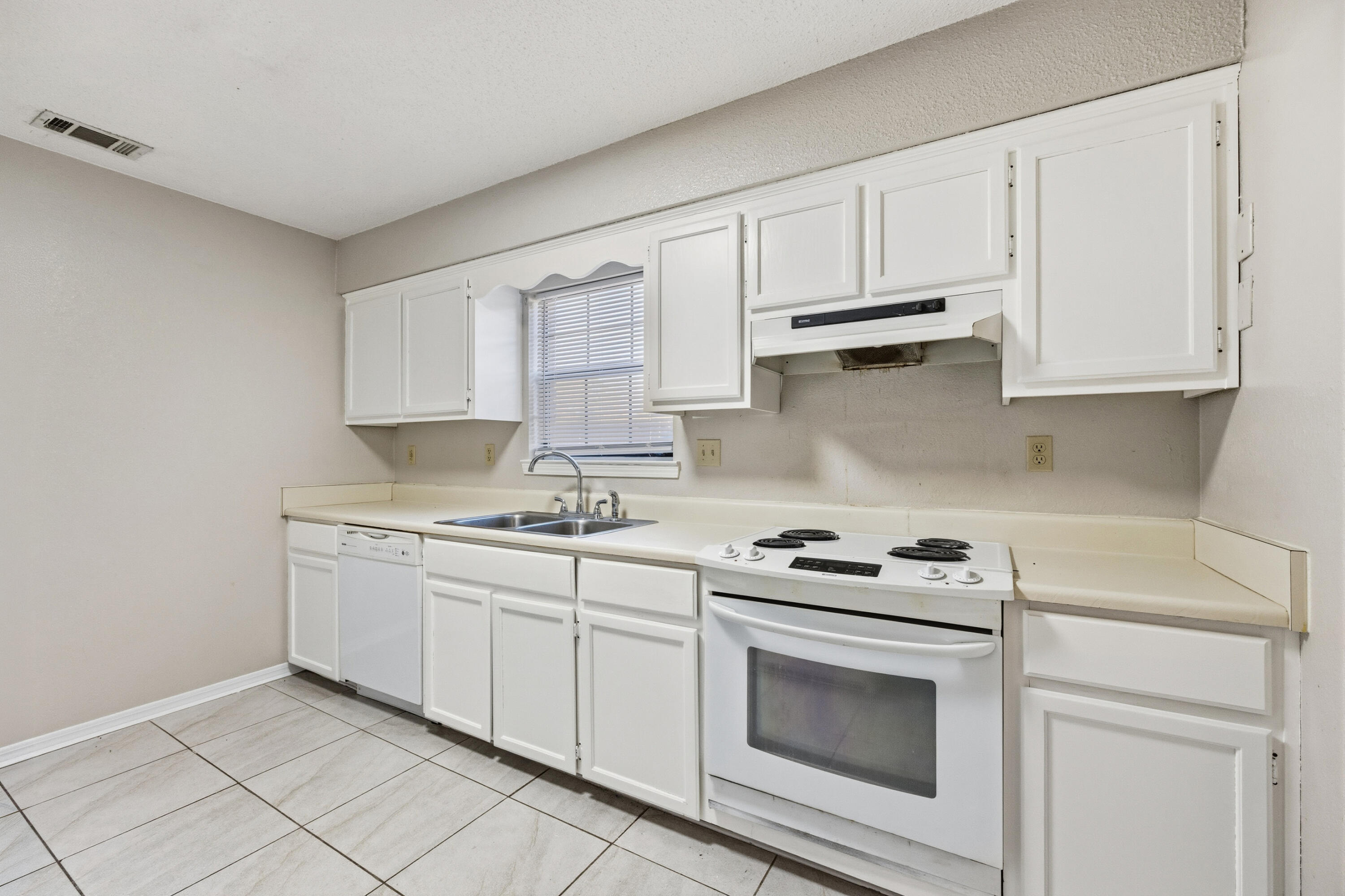 815 Valley Road Crestview, FL 32539 - Photo 10 of 40 a kitchen with granite countertop white cabinets and white appliances