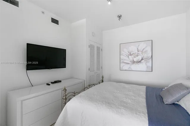 a bedroom with a bed and a flat screen tv