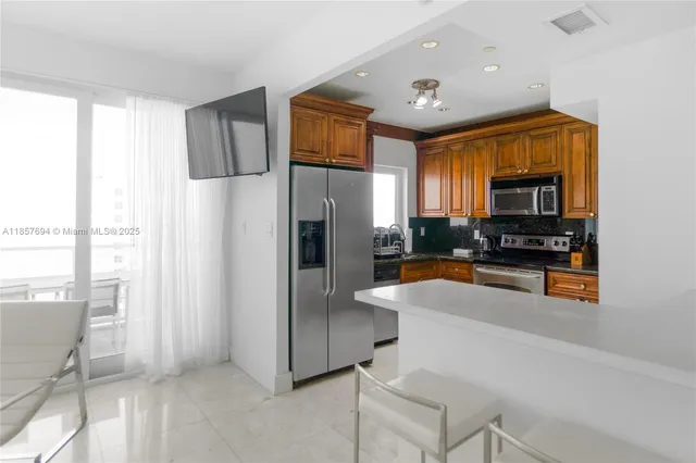 a kitchen with stainless steel appliances a refrigerator and a stove top oven