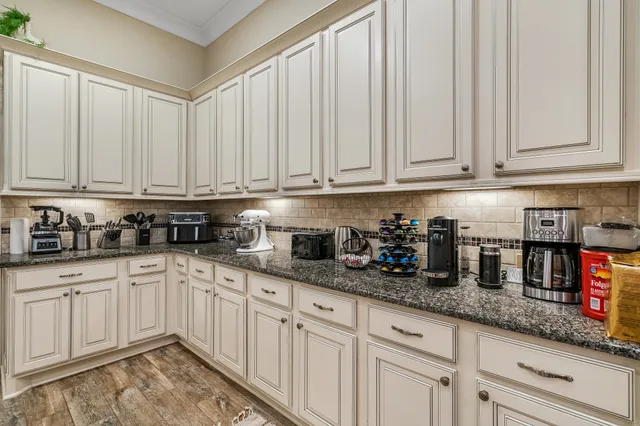 a kitchen with granite countertop white cabinets and white appliances