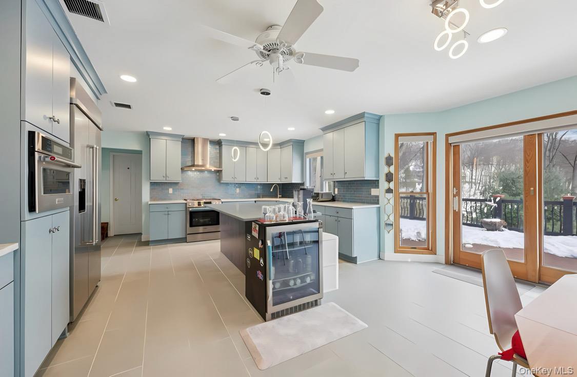 7 Gooler Court Stony Point, NY 10980 - Photo 12 of 35 Kitchen featuring a center island, hanging light fixtures, light countertops, wine cooler, and wall chimney range hood