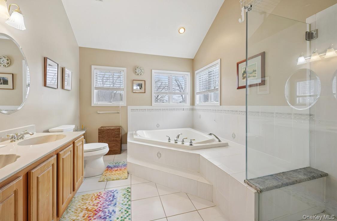 7 Gooler Court Stony Point, NY 10980 - Photo 23 of 35 Bathroom with a garden tub, double vanity, lofted ceiling, light tile patterned flooring, and a stall shower