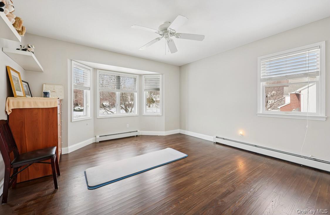 7 Gooler Court Stony Point, NY 10980 - Photo 26 of 35 Unfurnished room with dark wood-type flooring, a baseboard heating unit, and a ceiling fan
