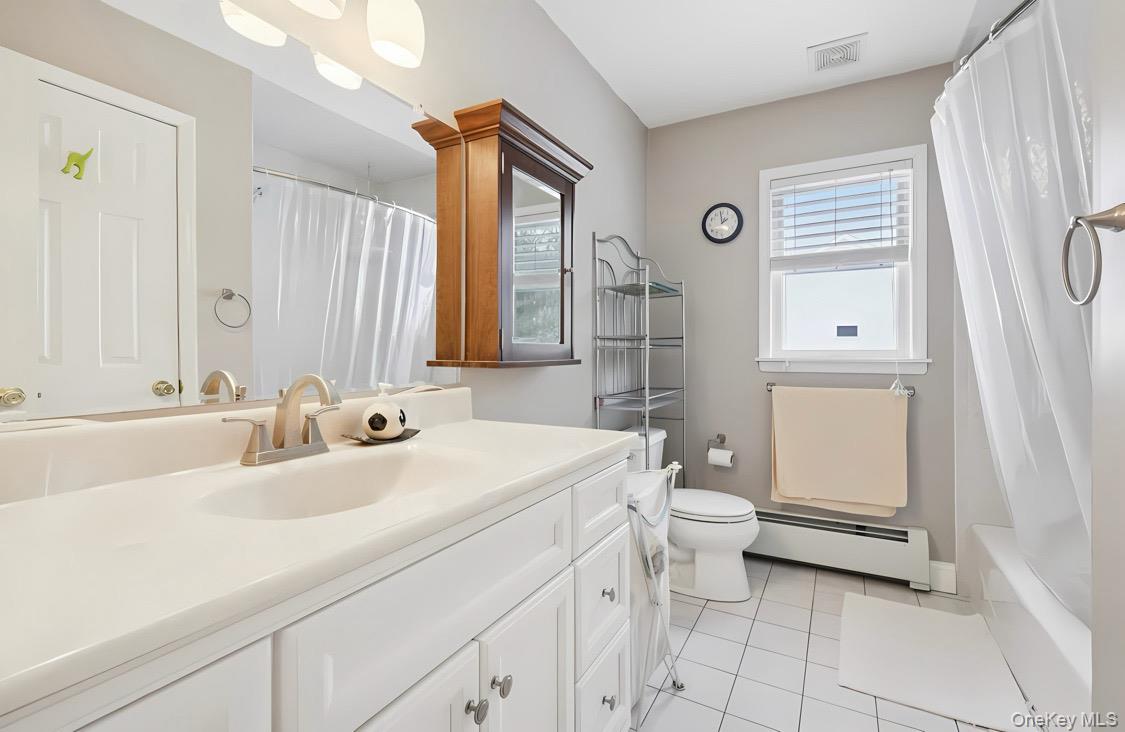 7 Gooler Court Stony Point, NY 10980 - Photo 27 of 35 Full bathroom featuring a baseboard heating unit, vanity, light tile patterned floors, and shower / tub combo