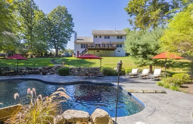 a front view of a house with a yard and a large tree