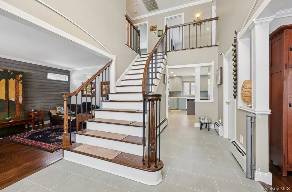 7 Gooler Court Stony Point, NY 10980 - Photo 4 of 35 Stairway with ornamental molding, tile patterned floors, a baseboard radiator, healthy amount of natural light, and a towering ceiling