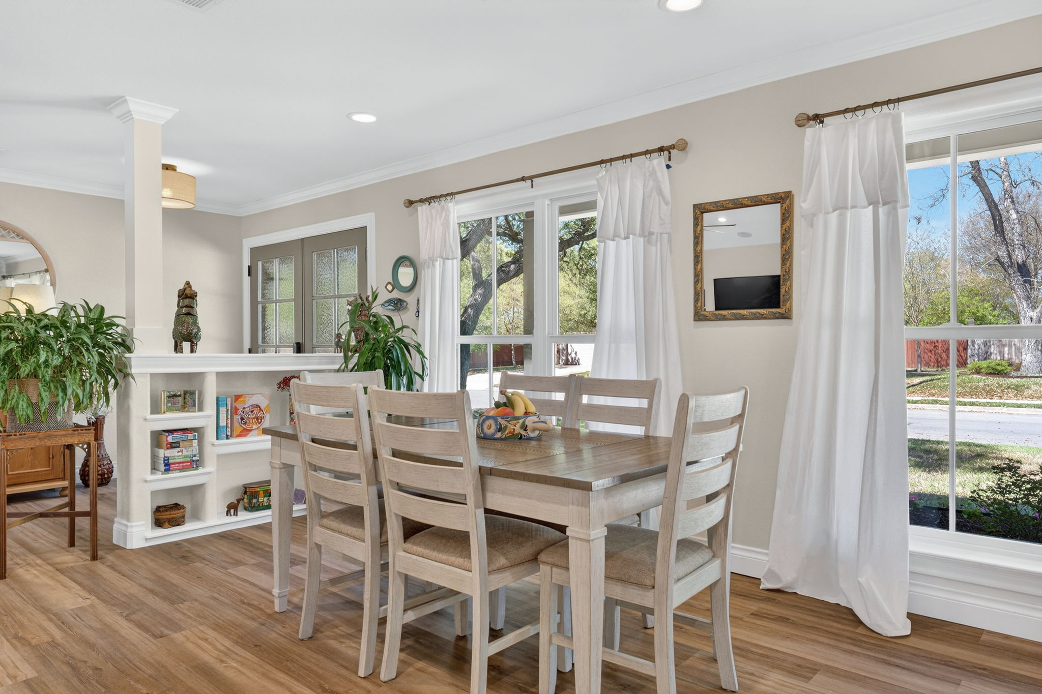 8611 Winding Walk Austin, TX 78757 - Photo 12 of 29 The dining area is bathed in natural light from large windows, featuring a table that seats six comfortably. A built-in bookshelf niche adds a touch of character and practical storage.