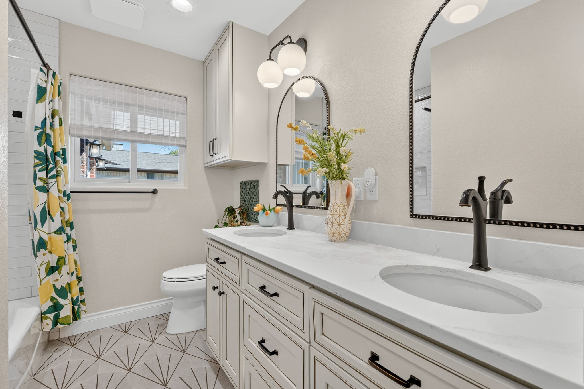 8611 Winding Walk Austin, TX 78757 - Photo 21 of 29 This bathroom features a spacious double vanity with sleek quartz countertops, updated fixtures, and a statement geometric tile floor that gives the room a sophisticated, custom feel.