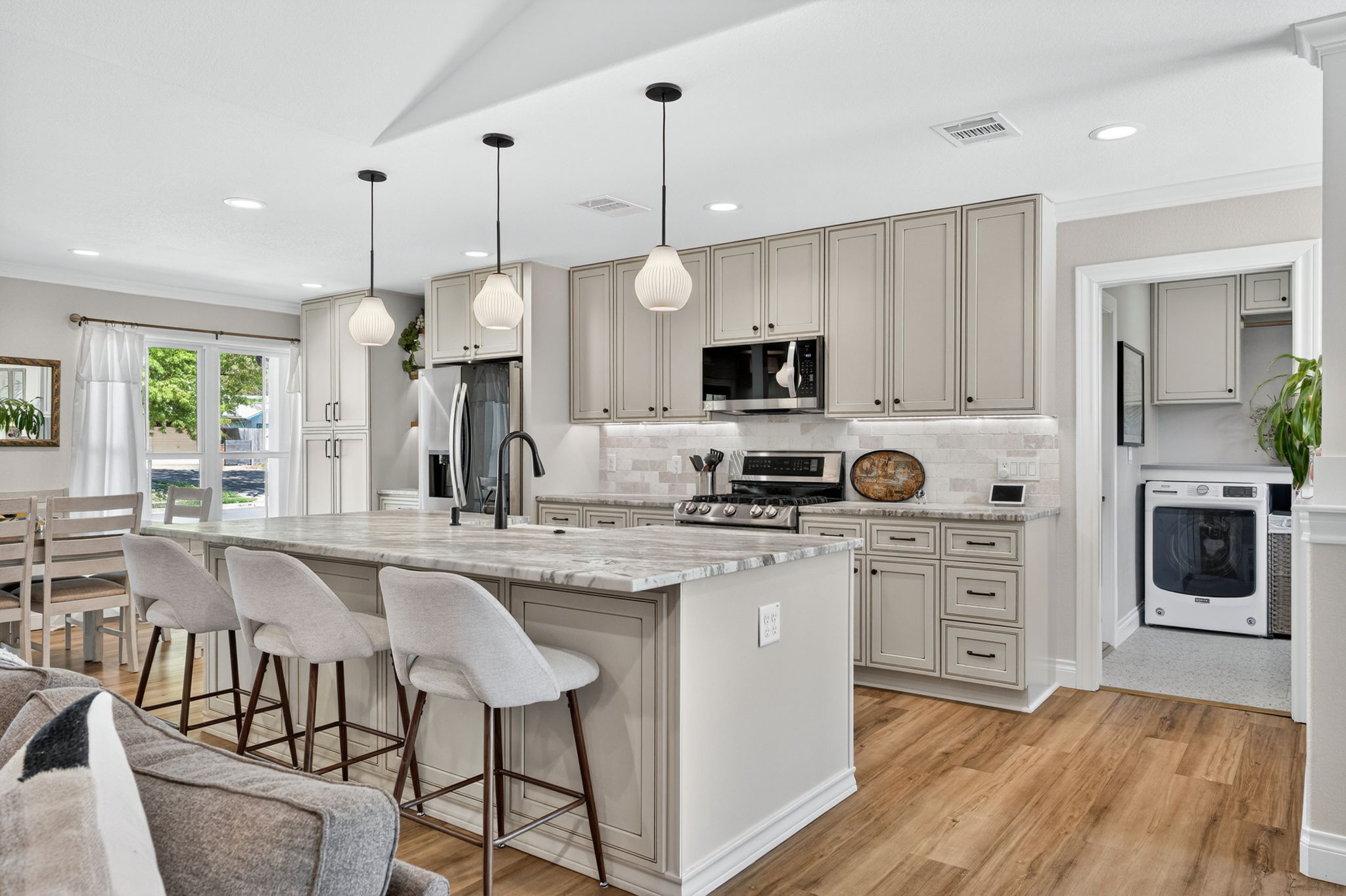 8611 Winding Walk Austin, TX 78757 - Photo 9 of 29 Modern shaker cabinetry reaches the ceiling, maximizing storage. A subway tile backsplash, Oil rubbed bronze hardware, and a view into the convenient adjoining laundry room make this kitchen as functional as it is beautiful.