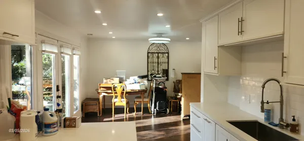a view of dining room and livingroom with furniture wooden floor a chandelier