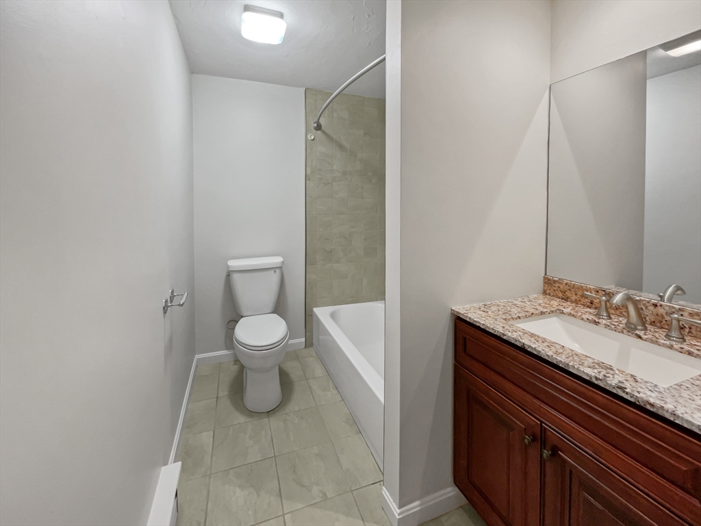 15 Cannongate Road, Unit 48 Tyngsborough, MA 01879 - Photo 16 of 25 a bathroom with a granite countertop sink toilet and a mirror