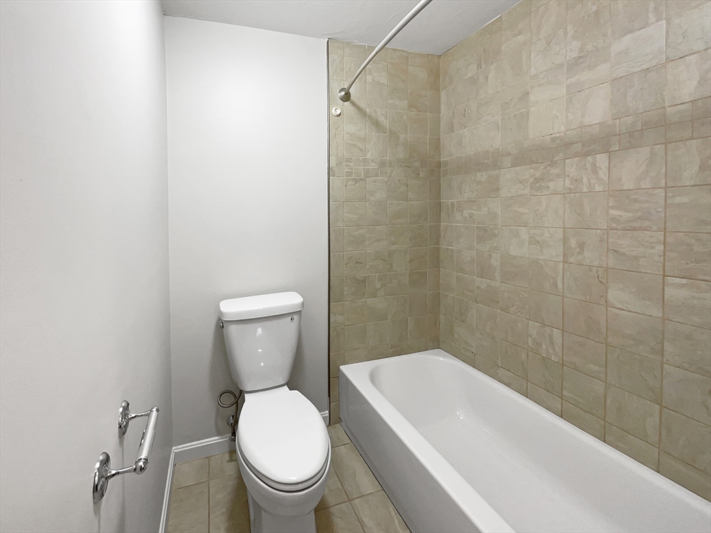 15 Cannongate Road, Unit 48 Tyngsborough, MA 01879 - Photo 18 of 25 a white toilet sitting next to a bath tub