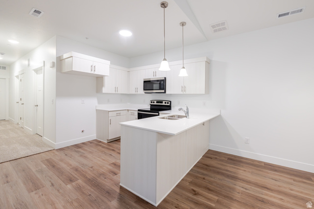 4661 Poplar Way, Unit R301 Mapleton, UT 84664 - Photo 12 of 17 Kitchen featuring stainless steel appliances, white cabinetry, a peninsula, and light wood-style flooring