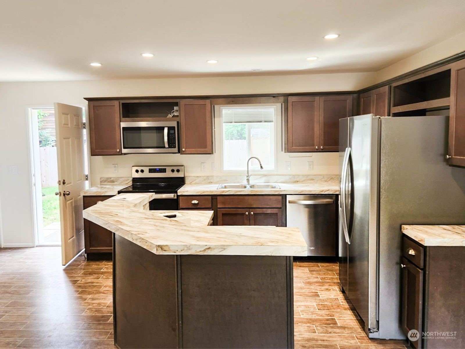 2681 Northeast John Carlson Road Bremerton, WA 98311 - Photo 6 of 15 a kitchen with stainless steel appliances granite countertop a refrigerator a stove a sink a microwave and wooden cabinets