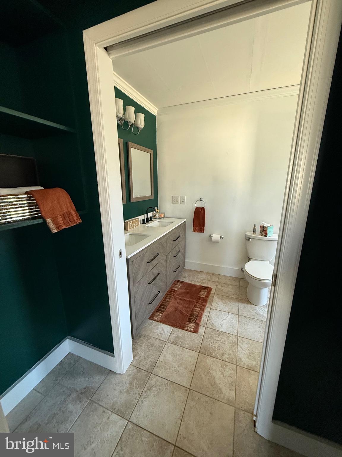 23055 Old Fairlee Road Chestertown, MD 21620 - Photo 16 of 26 a bathroom with a sink a toilet a mirror and vanity
