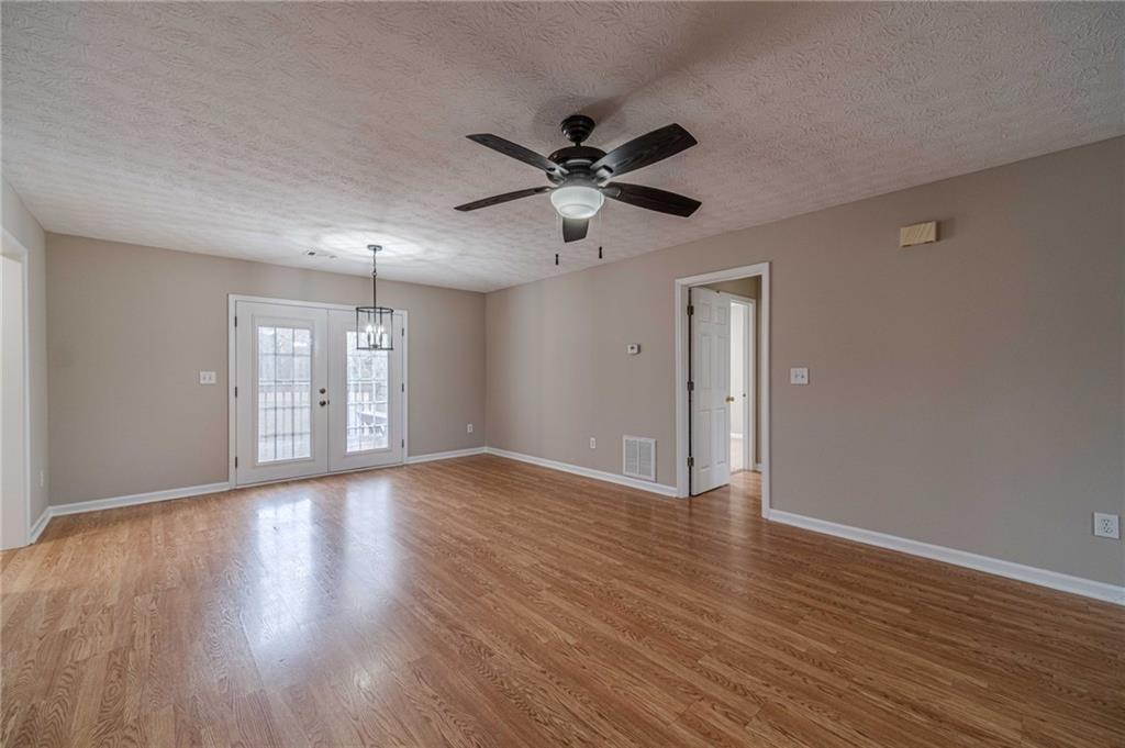 119 West Ash Street Social Circle, GA 30025 - Photo 12 of 44 a view of an empty room with window and wooden floor