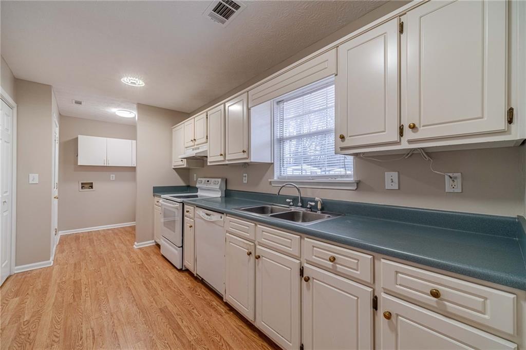 119 West Ash Street Social Circle, GA 30025 - Photo 15 of 44 a kitchen with granite countertop wooden cabinets stainless steel appliances a sink and a window