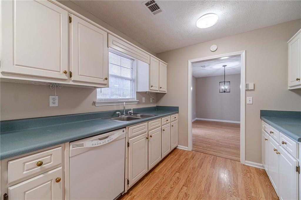 119 West Ash Street Social Circle, GA 30025 - Photo 17 of 44 a kitchen with granite countertop wooden cabinets and white appliances