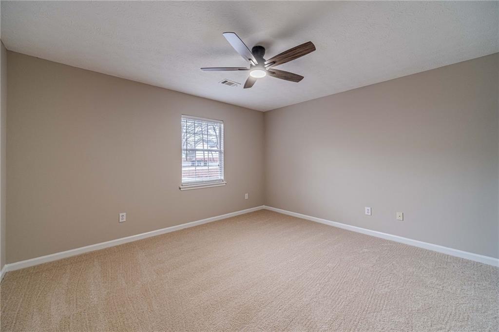 119 West Ash Street Social Circle, GA 30025 - Photo 20 of 44 an empty room with a window and a fan