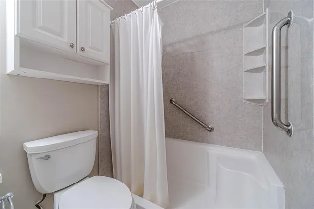 a bathroom with a toilet and a shower