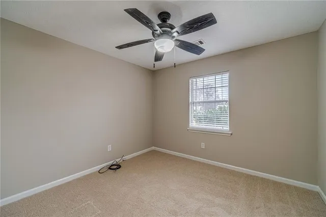 an empty room with a window and a fan