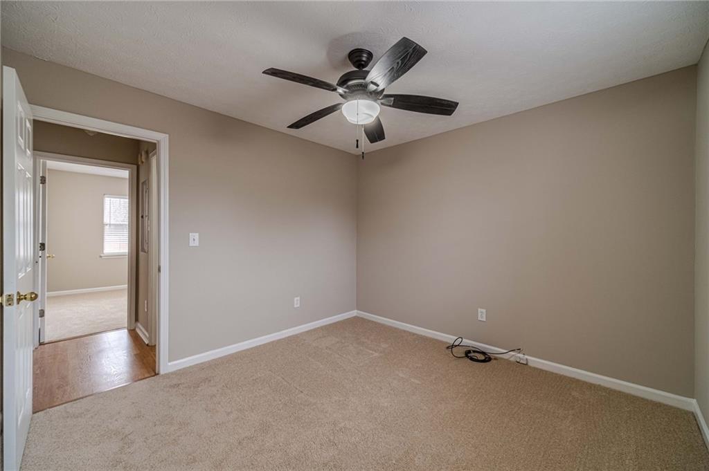 119 West Ash Street Social Circle, GA 30025 - Photo 29 of 44 an empty room with ceiling fan and window