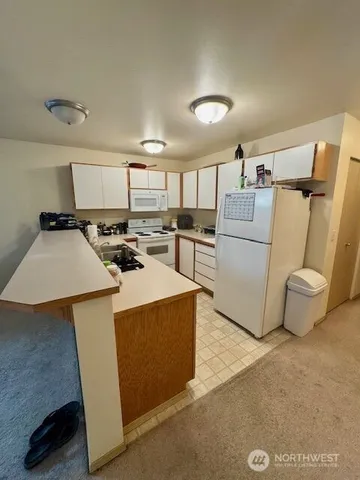 a kitchen with appliances a refrigerator and a stove top oven