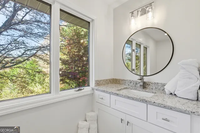 a bathroom with a granite countertop sink and a mirror