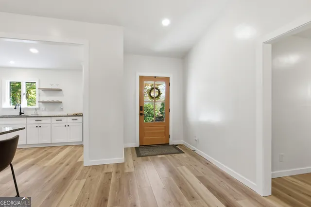 a kitchen with stainless steel appliances granite countertop a kitchen island a stove a cabinets a sink and a chairs