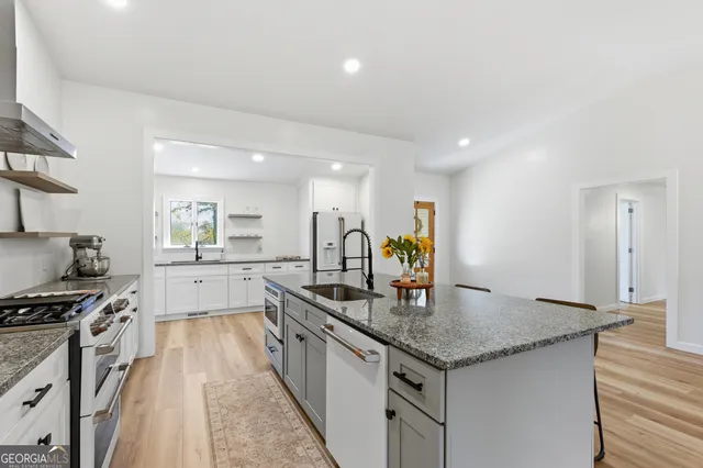 a kitchen with granite countertop white cabinets and white appliances