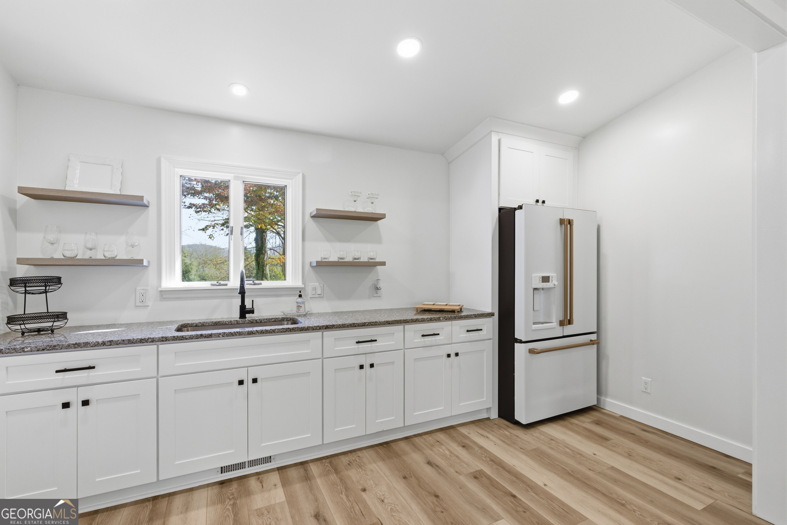 230 Majors Lane Rabun Gap, GA 30568 - Photo 24 of 54 a kitchen with granite countertop white cabinets and white appliances