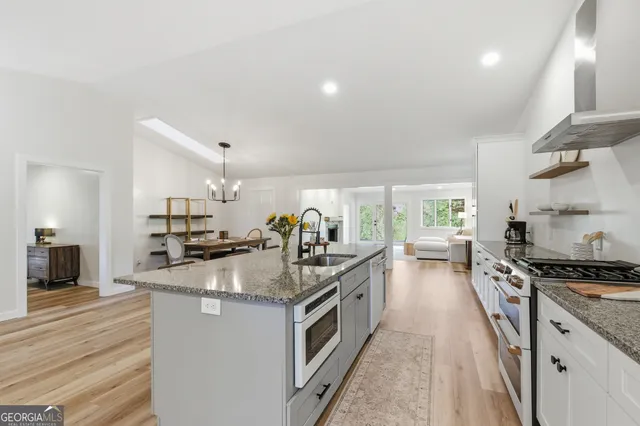 a view of a dining room with furniture a chandelier and wooden floor