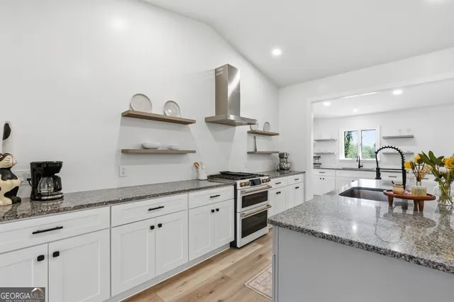 a kitchen with granite countertop a sink stainless steel appliances and cabinets