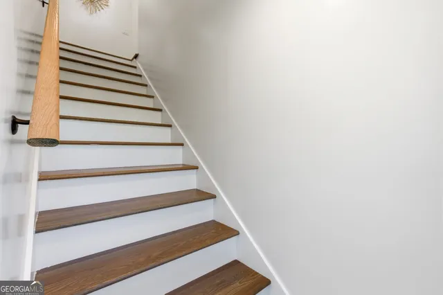 a backyard of a house with large trees and plants