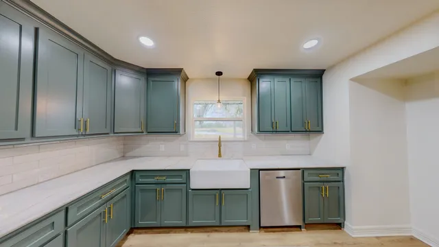 a kitchen with kitchen island granite countertop a sink and a refrigerator