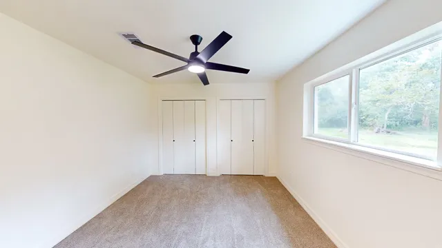 a view of a livingroom with a ceiling fan and window