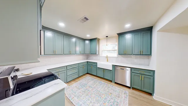a large kitchen with a sink and dishwasher a stove with wooden floor