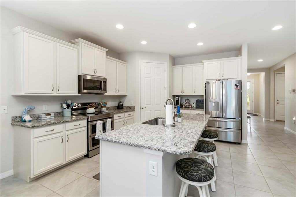 20765 Swallowtail Court Venice, FL 34293 - Photo 14 of 50 a kitchen with stainless steel appliances granite countertop a sink stove and refrigerator