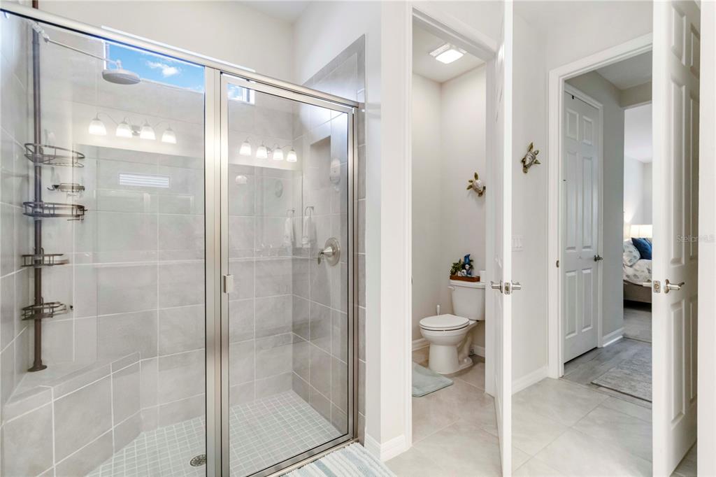 20765 Swallowtail Court Venice, FL 34293 - Photo 17 of 50 a bathroom with a glass shower door