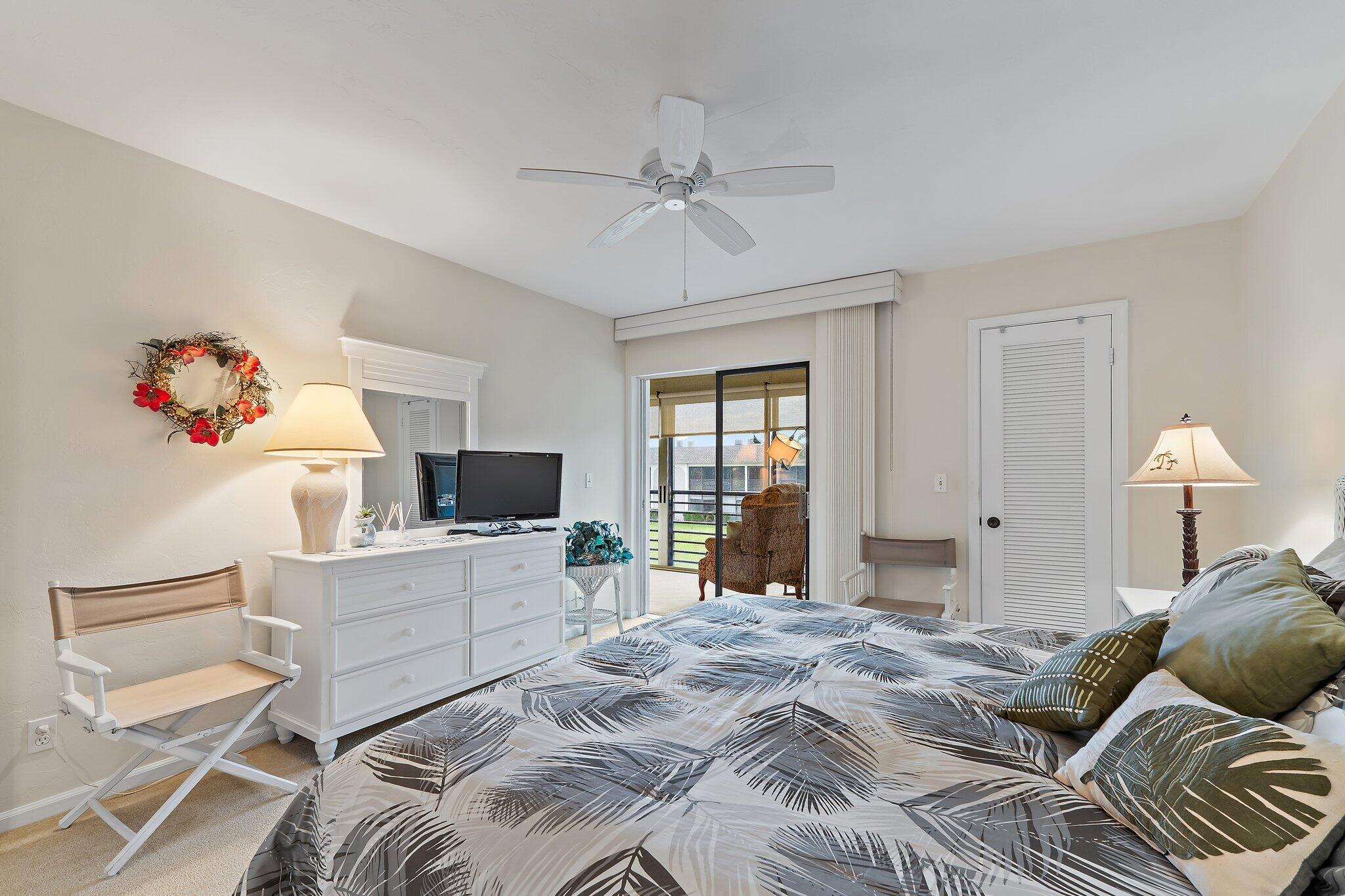 755 Saturn Street, Unit I 206 Jupiter, FL 33477 - Photo 18 of 26 a bedroom with a bed and a chandelier