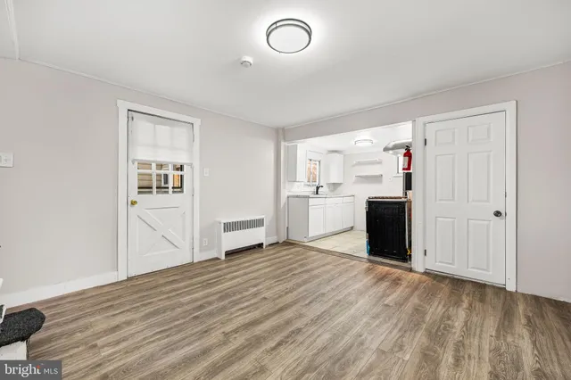 a view of a kitchen with wooden floor electronic appliances and windows