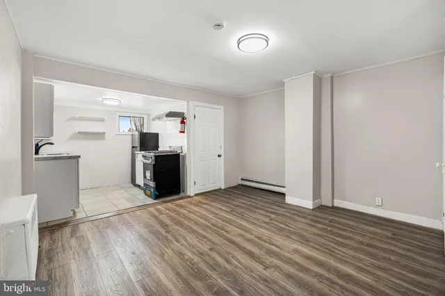 a view of a kitchen with fridge and wooden floor