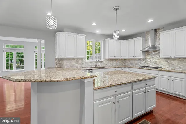 a kitchen with kitchen island granite countertop a sink a center island and cabinets